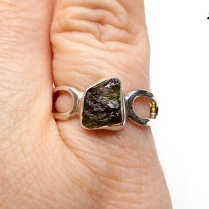 May include: A silver ring with a green and black gemstone set in a unique open design. #3