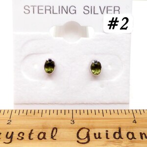 May include: Sterling silver earrings with green oval gemstones on a white card with the text "STERLING SILVER #2".