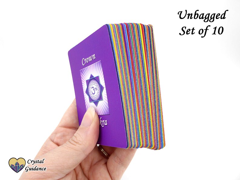 Pu&ograve; includere: Un set di 10 carte dei chakra viola con bordi arcobaleno. La carta superiore mostra il simbolo del chakra della corona e la parola "Corona" in testo bianco. Il testo "Unbagged Set of 10" &egrave; visibile nell'angolo in alto a destra dell'immagine.