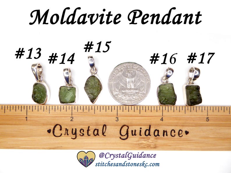 May include: Five silver pendants with green moldavite stones. The pendants are numbered 13, 14, 15, 16, and 17. The pendants are displayed on a wooden ruler with the text "Crystal Guidance" printed on it.