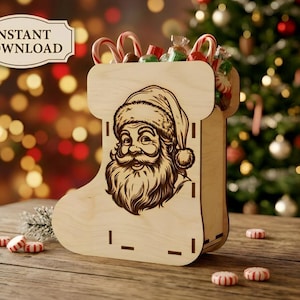 May include: A light-colored wooden stocking-shaped container featuring a laser-engraved illustration of Santa Claus on the front. The container is filled with candy canes and peppermint candies, with additional candies scattered nearby.