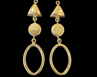 May include: A pair of gold-colored earrings with a geometric design. Each earring features a small triangle, a circle, and an oval shape, all connected by small loops. The earrings are displayed against a black background.