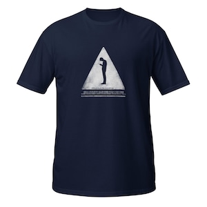 May include: A navy blue short-sleeve t-shirt featuring a white triangle graphic containing a silhouette of a person looking at a phone. Below the triangle, the text reads "ENSLAVED BY THE ALGORITHM" followed by several lines of small, illegible text.