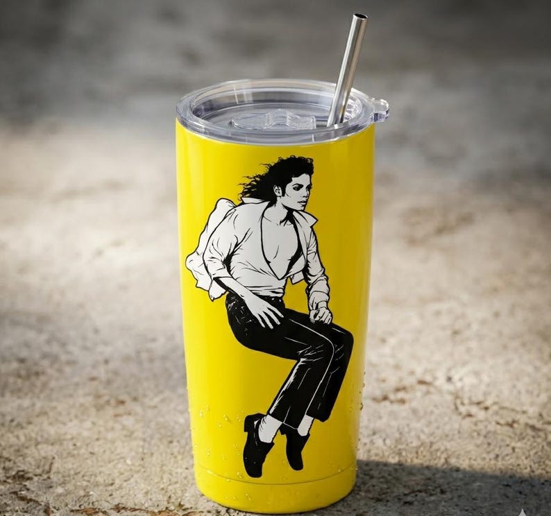 May include: A bright yellow stainless steel tumbler with a clear plastic lid and a metal straw. The tumbler features a black and white graphic illustration of a person with long dark hair wearing a white shirt and dark trousers in a seated pose.
