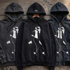 May include: Three hooded sweatshirts featuring a white graphic print of a person in a hat and suit performing a dance move. The center hoodie is solid black, while the left and right hoodies are a faded charcoal gray, with the right one featuring a zipper.