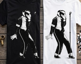 May include: A black t-shirt and a white t-shirt, each featuring a graphic illustration of a performer in a fedora, jacket, and trousers, holding a hand to their face while standing next to a microphone stand on a thin, vertical pole.