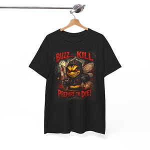 May include: Black t-shirt with a cartoon bee graphic, holding a bloody knife. The text "Buzz... Kill" and "Prepare to Die!" are printed in red. The bee is wearing a hooded sweatshirt. The design has a horror theme.