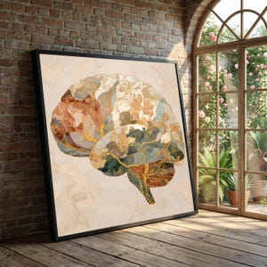 Könnte beinhalten: Ein gerahmter Kunstdruck mit einer aquarellartigen Darstellung eines menschlichen Gehirns. Das Kunstwerk verwendet Erdtöne, darunter Braun-, Gold- und Grüntöne, vor einem beigen Hintergrund. Der Druck wird auf einem Holzboden präsentiert.