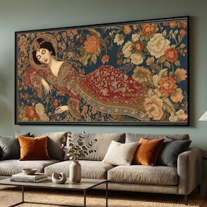 Puede incluir: Una gran obra de arte enmarcada representa a una mujer reclinada sobre un tapiz floral. La mujer viste un vestido con estampado rojo y dorado, con un tocado floral. El fondo es azul oscuro, con grandes flores naranjas y crema.