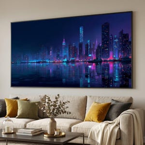 Op de afbeelding: Een groot ingelijst canvasdoek dat een nachtelijke stadsgezicht toont met heldere neonlichten die weerspiegelen in het water. Het kunstwerk heeft een donkerblauw en paars kleurenschema, met hoge gebouwen en een waterpartij op de voorgrond.