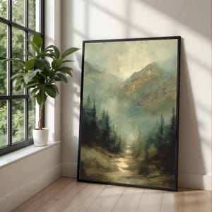 Könnte beinhalten: Ein gerahmter Kunstdruck, der eine neblige Berglandschaft mit einem Pfad durch einen Wald zeigt. Das Kunstwerk verwendet Grün-, Braun- und Goldtöne und erzeugt eine ruhige, natürliche Ästhetik. Der Druck wird in einem schwarzen Rahmen präsentiert.