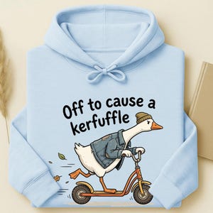 Könnte beinhalten: Hellblauer Kapuzenpullover mit einer Grafik einer Gans auf einem Roller, die eine Jacke und eine Mütze trägt. Der Text "Off to cause a kerfuffle" steht über der Gans. Der Hoodie hat einen Kordelzug und eine Vordertasche.
