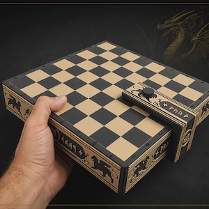 May include: A square chess board with a black and tan checkered pattern. The sides of the board feature intricate cut-out designs of mythical creatures and runic-style symbols. A rectangular latch with a black knob secures the board closed.
