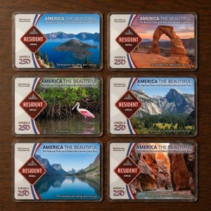 May include: Six "America the Beautiful" National Parks and Federal Recreational Lands Passes. Each pass features a different scenic landscape, including mountains, arches, and lakes. The passes are labeled "Resident Annual" and "America 250". The text "The mountains are calling, and I must go" is also included.