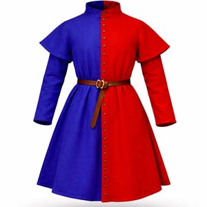 Puede incluir: Una túnica de estilo medieval bicolor en azul y rojo, con cuello alto y mangas largas. La túnica está dividida verticalmente, con un lado azul y el otro rojo. Tiene un cinturón marrón y se abrocha con pequeños botones redondos.
