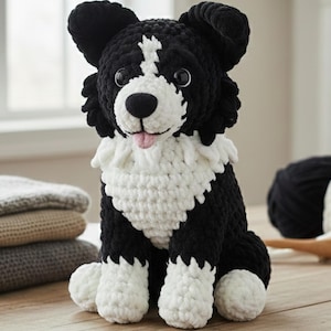 May include: A handmade crochet dog in black and white, resembling a Border Collie. The dog has a pink tongue and is sitting upright. Beside it are folded blankets and yarn balls.