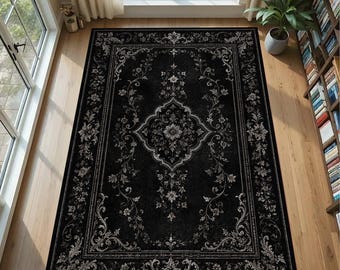 Op de afbeelding: Een rechthoekig vloerkleed met een zwarte achtergrond en een gedetailleerd wit en lichtgrijs bloemrijk damastpatroon. Het ontwerp bevat een centraal medaillon omringd door ingewikkelde krullende ranken en een decoratieve rand.