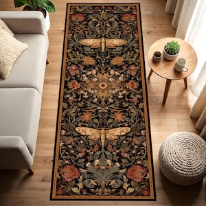 May include: A rectangular rug with a black background and a detailed floral and insect design. The rug features a symmetrical pattern with large moths and various flowers in shades of gold, red, and green. The rug has a gold border.