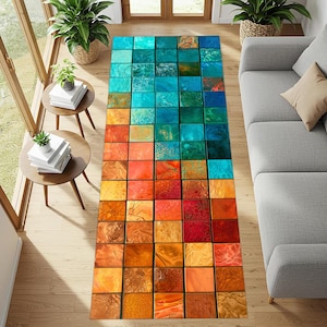 May include: A rectangular area rug featuring a grid of square tiles in a gradient of colors. The pattern transitions from cool shades of blue and teal at the top to warm tones of orange, yellow, and deep red at the bottom, with varied textures.