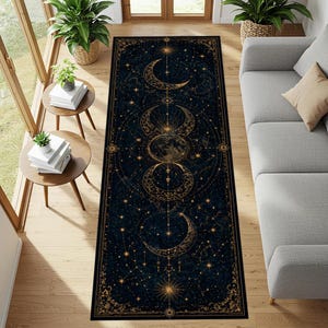 Peut inclure: Un tapis rectangulaire avec un fond bleu foncé et un motif céleste. Le motif présente des croissants de lune dorés, des étoiles et des motifs célestes. Le tapis est posé sur un sol en bois, près d'un canapé gris et de petites tables.