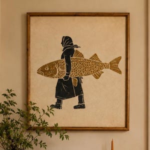Könnte beinhalten: Ein quadratisches gerahmtes Wandbild mit der schwarzen Silhouette einer Person, die einen großen goldenen Fisch trägt. Das Kunstwerk hängt über einem hölzernen Konsolentisch mit einer Keramikvase mit Grünpflanzen, einer Schale, Büchern, einem roten Topf und einer Kerze.