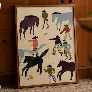 Puede incluir: Impresión artística enmarcada con una ilustración caprichosa de caballos y vaqueros. La obra de arte muestra caballos en tonos morados, azules y negros, con vaqueros con varios atuendos. La impresión se muestra en un marco de madera.