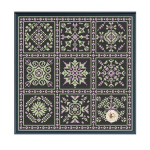 May include: A framed cross-stitch sampler with a dark background and a grid of nine squares. Each square features a different geometric design in shades of green and lavender. The frame is dark blue. A small logo is in the bottom right corner.