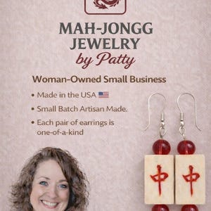 May include: Mah-Jongg Jewelry by Patty earrings. The earrings feature cream-colored rectangular tiles with red Chinese characters and red beads. The image also includes the text "Made in the USA" and "Woman-Owned Small Business."
