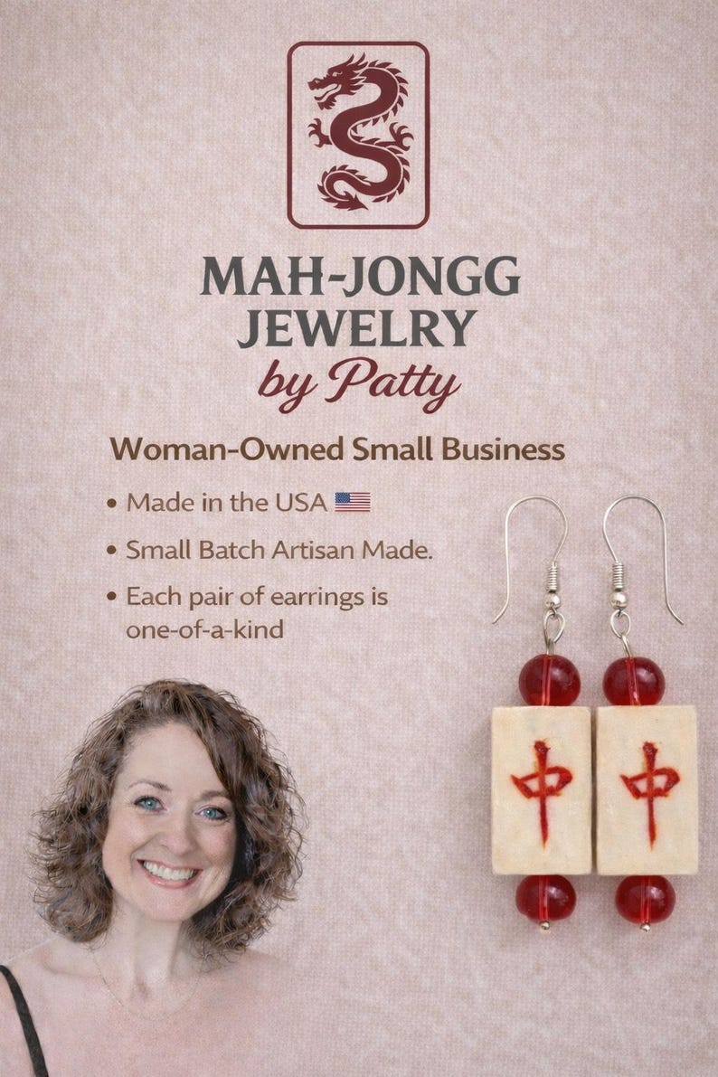 May include: Mah-Jongg Jewelry by Patty earrings. The earrings feature cream-colored rectangular tiles with red Chinese characters and red beads. The image also includes the text "Made in the USA" and "Woman-Owned Small Business."