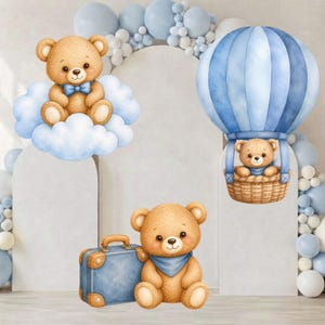 Può includere: Un'illustrazione ad acquerello con tre orsacchiotti marrone chiaro. Un orso è seduto su una nuvola bianca, un altro nel cesto di una mongolfiera blu e il terzo è seduto accanto a una valigia blu. La scena include palloncini blu e bianchi.