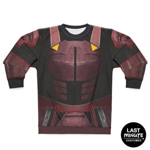 May include: Black sweatshirt featuring a burgundy and black armor design. The costume-style top has a crew neck and long sleeves. The design includes yellow accents and a detailed chest plate. The Last Minute Costumes logo is in the bottom right corner.