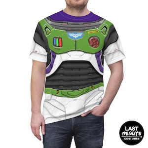 Könnte beinhalten: Ein weißes T-Shirt mit einem Buzz Lightyear Kostümdesign. Die Grafik enthält grüne, weiße, lila und schwarze Elemente, darunter das Lightyear-Logo und taktische Knöpfe. Das T-Shirt hat einen lila Kragen und kurze Ärmel.