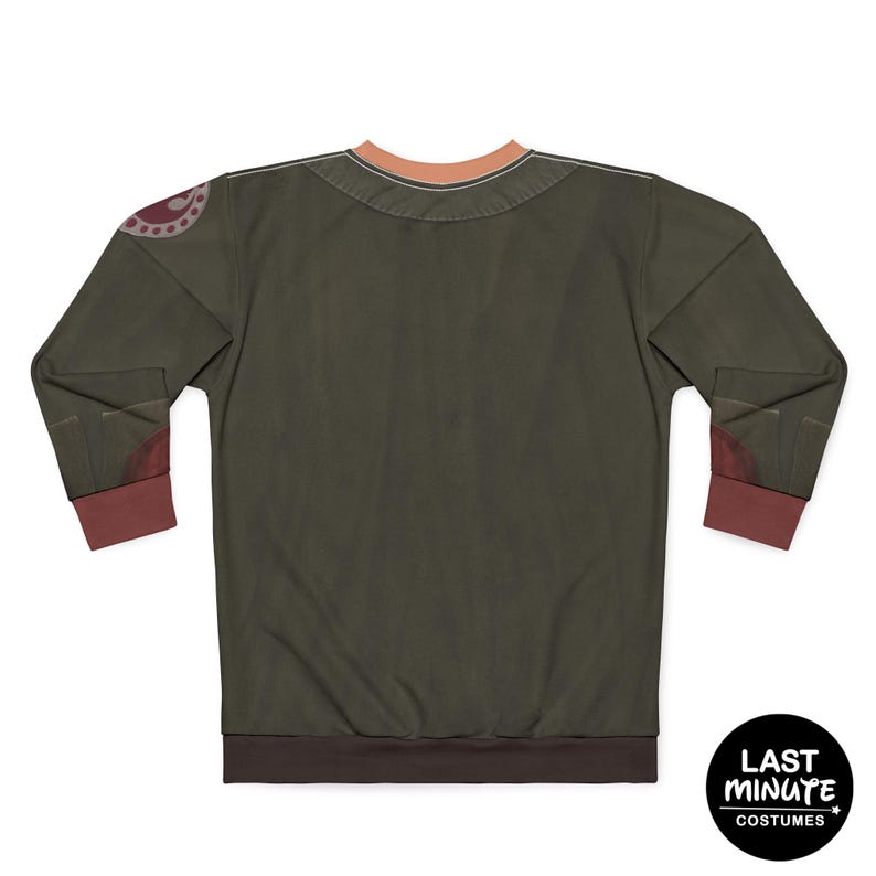 May include: Olive green long-sleeve shirt with brown cuffs and collar trim. The shirt has a circular design on the left shoulder and a brown hem. The back of the shirt is visible. The shirt has the text "LAST MINUTE COSTUMES" on a black circle.
