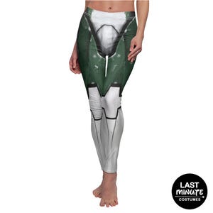 May include: White and green leggings with a printed design resembling armor. The leggings feature a detailed graphic with green and white panels, black accents, and a realistic, textured appearance. The leggings are form-fitting and suitable for cosplay or themed events.