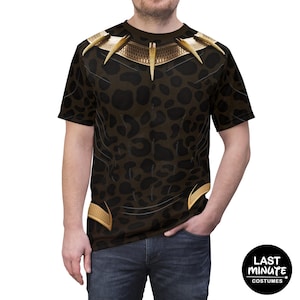 Könnte beinhalten: Ein kurzärmeliges T-Shirt mit einem Black Panther-Kostümdesign. Das Shirt hat ein braunes Leopardenmuster mit goldenen Akzenten am Ausschnitt und an den Schultern. Das Logo von Last Minute Costumes ist unten rechts sichtbar.