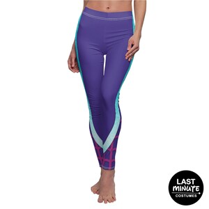 May include: Purple leggings with teal and light blue side panels and a geometric design at the ankles. The leggings have a high waist and are made of a stretchy material. The Last Minute Costumes logo is in the bottom right corner.