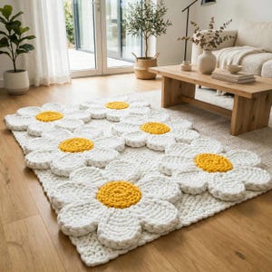 May include: A rectangular area rug featuring a repeating pattern of large, three-dimensional daisy flowers. The rug is constructed from thick, white yarn for the petals and bright yellow yarn for the circular centers, creating a textured surface.