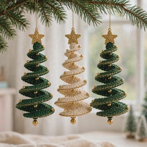 May include: Three hanging Christmas tree ornaments crafted from crocheted yarn. Two trees are dark green and one is cream, each featuring a spiral design, small gold beads along the edges, and a crocheted gold star topper suspended by a thin string.
