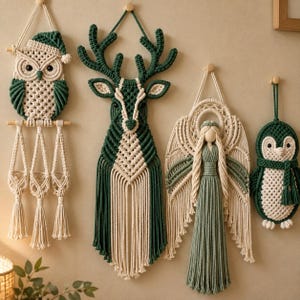 May include: Four macrame wall hangings in cream and dark green cord. The set includes an owl with three hanging pockets, a deer head with antlers, a winged angel figure with a long dress, and a penguin wearing a scarf, all suspended by cords.