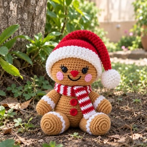 May include: A crocheted gingerbread person doll featuring a tan body, a red and white Santa hat with a pom-pom, a red and white striped scarf, two red buttons on the chest, pink cheeks, black eyes with eyelashes, and white icing-like trim.