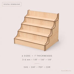 Può includere: Un espositore a quattro livelli in legno chiaro con supporti laterali. Il testo recita: DIGITAL DOWNLOAD, 6 SIZES, 7 THICKNESSES, 3-6 mm, 1/8", 1/6", 1/4", SVG, DXF, PDF, CDR, KameWorks. La struttura presenta ripiani piatti per organizzare.