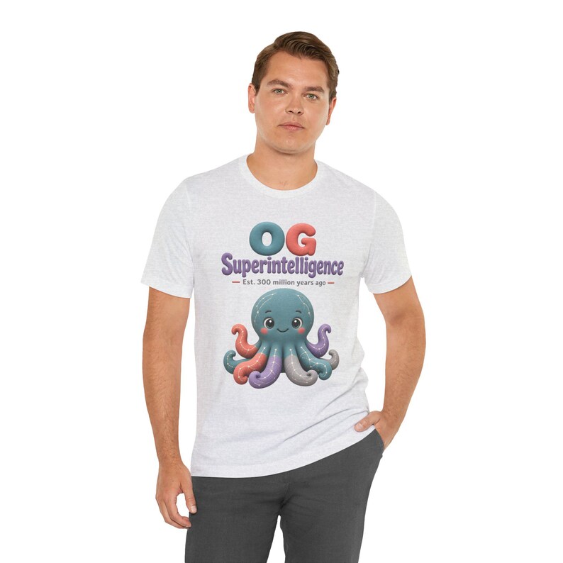 May include: A light heather gray short-sleeve t-shirt featuring a graphic of a teal octopus with multicolored tentacles. Above the octopus, the text reads OG Superintelligence, followed by the smaller text Est. 300 million years ago.