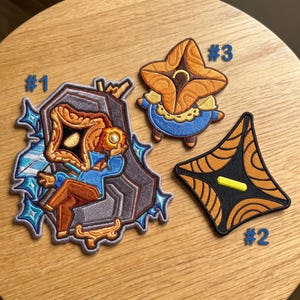 Broderad lapp med texten Regent Slay The Spire, detaljerad indie-spelsetikett, anpassad stryk-på-applikation, unik spelgåva.