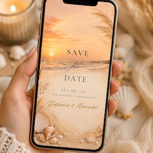 May include: A smartphone displaying a digital Save the Date announcement featuring a sunset beach scene with seashells, pampas grass, and the text: SAVE the DATE, 15 . 08 . 27, hochzeitsstraße 7, 25684 Hochzeit, and Stephanie & Alexander.