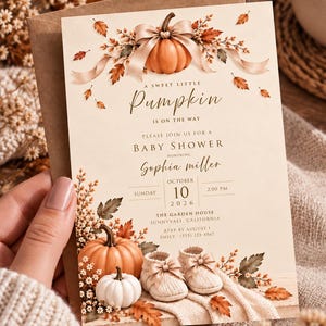 Könnte beinhalten: Eine cremefarbene Babyparty-Einladungskarte mit Illustrationen von orangefarbenen Kürbissen, Herbstblättern und Babyschuhen. Der Text lautet A Sweet Little Pumpkin Is On The Way, Baby Shower, Sophia Miller, Sonntag, 10. Oktober 2026, 14:00 Uhr.