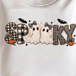 Könnte beinhalten: Ein weißes Kurzarm-T-Shirt mit dem Wort SPOOKY in einem schwarz-weiß karierten und gestreiften Muster. Zwei weiße Geister mit schwarzen Schleifen sind zwischen den Buchstaben platziert, begleitet von kleinen orangefarbenen Kürbissen und schwarzen Fledermäusen.