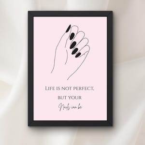 Puede incluir: Lámina artística enmarcada en negro con un dibujo lineal minimalista de una mano con uñas largas y negras sobre fondo rosa. El texto dice: "LIFE IS NOT PERFECT, BUT YOUR Nails can be."