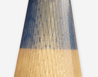May include: A blue and beige pendant lamp shade with a textured, geometric pattern. The top half is a deep blue, transitioning to a beige bottom. The shade is cone-shaped and suspended from a wooden rod.