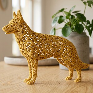 May include: A golden-yellow decorative dog sculpture. The dog is standing, with intricate, openwork filigree patterns throughout its body. The sculpture has pointed ears and a long tail, and is placed on a wooden surface.