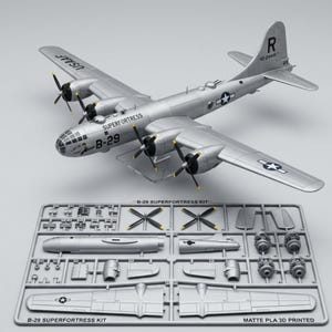 May include: A silver B-29 Superfortress model airplane with four propellers and the text "SUPERFORTRESS" and "B-29". The model kit includes various unassembled parts. The text "B-29 SUPERFORTRESS KIT" is visible.